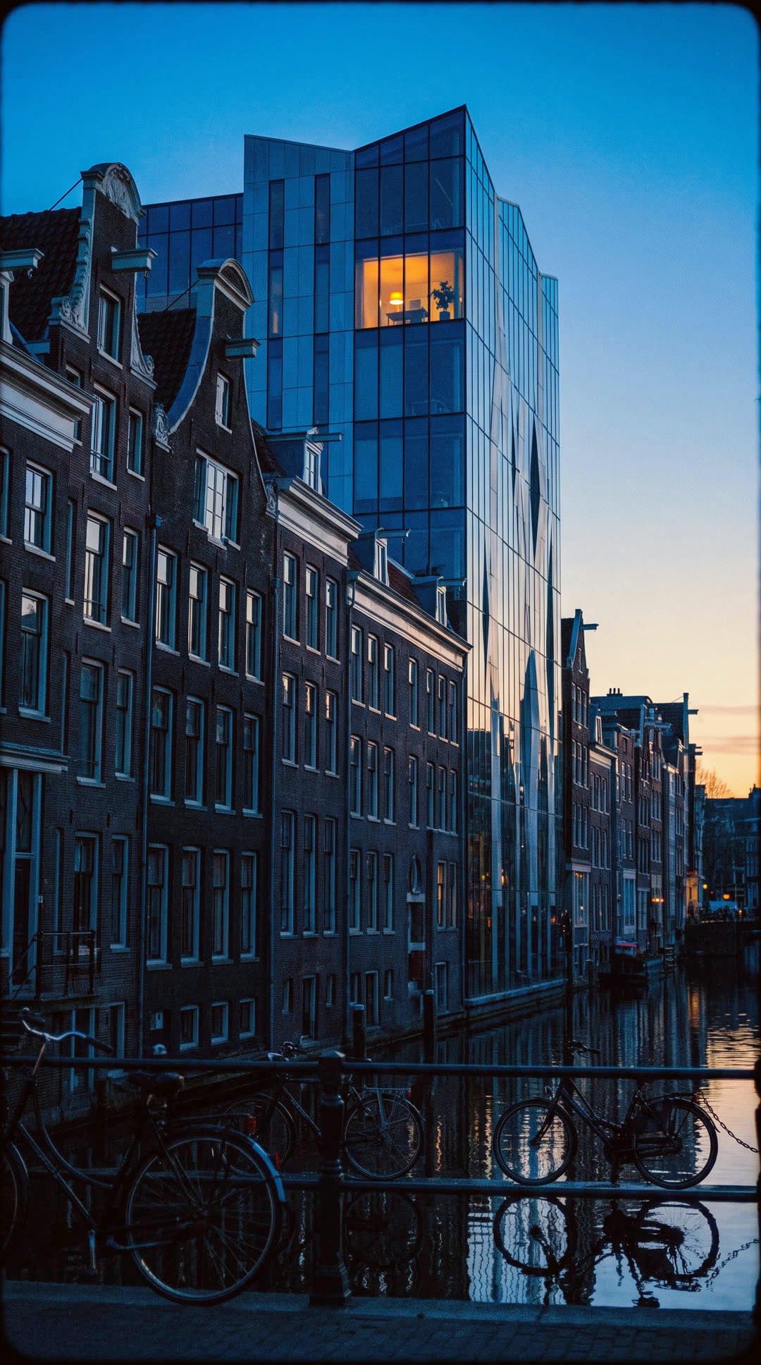 Amsterdam canal at blue hour in morning colour, one office window lit